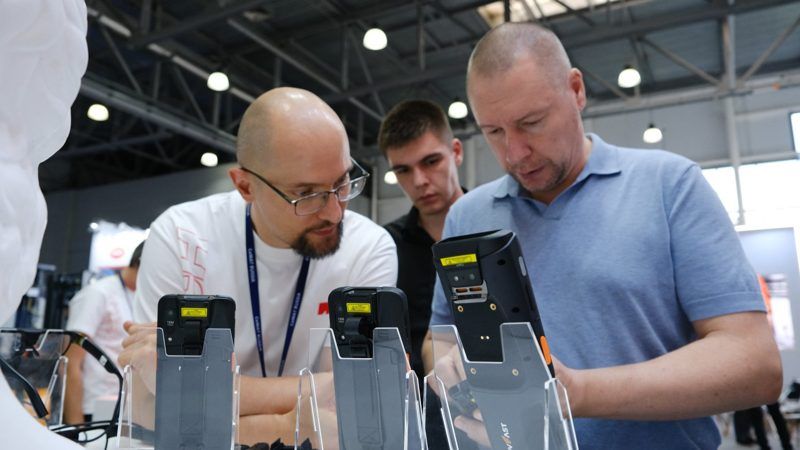 MERTECH employee demonstrating a mobile computer to customers